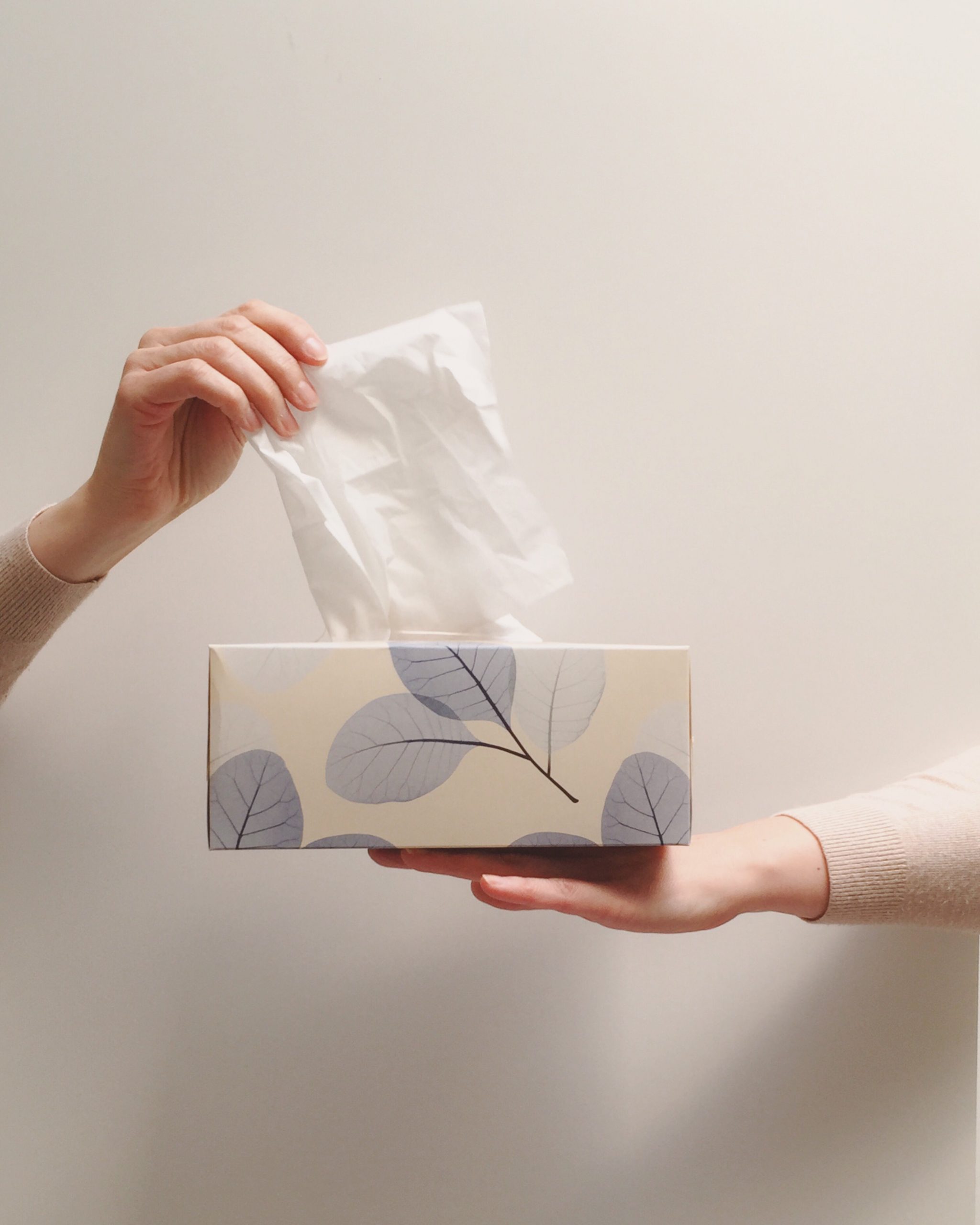 Hand taking tissue from a box
